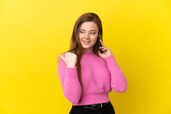 Adolescente Chica Usando Teléfono Móvil Sobre Aislado Fondo Amarillo Apuntando — Foto de Stock