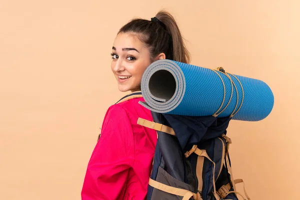 若いです山の少女とともに大バックパッカー孤立上のベージュの背景 — ストック写真