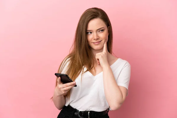 Adolescente Chica Sobre Aislado Rosa Fondo Utilizando Teléfono Móvil Pensando — Foto de Stock