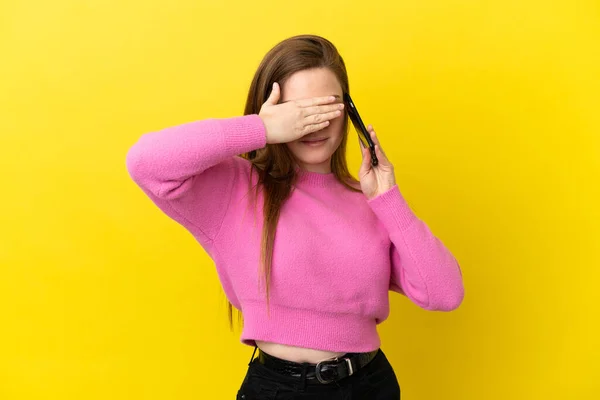 Teenager Mädchen Mit Handy Über Isolierten Gelben Hintergrund Zeigt Nach — Stockfoto