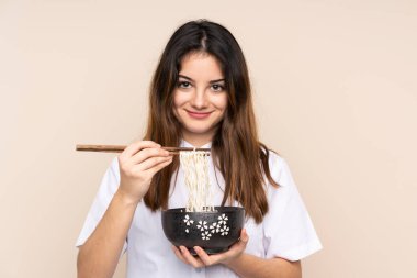 Bir kase erişteyi izole edilmiş arka planda tutan bir kız.