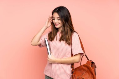 Üniversiteye giden genç bir bayan izole pembe arka planda gülüyor.