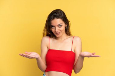 Sarı arka planda izole edilmiş genç beyaz kadın kuşkuları var.