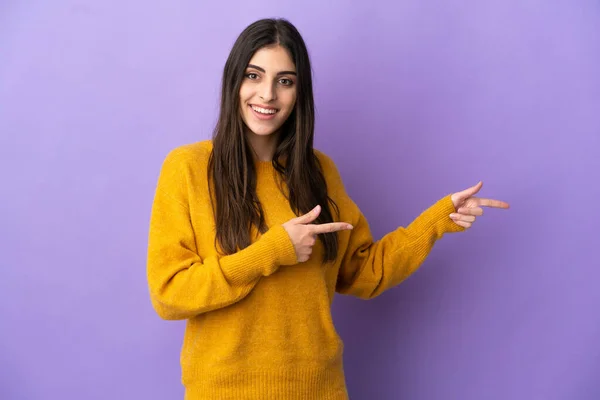 Junge Kaukasische Frau Isoliert Auf Violettem Hintergrund Überrascht Und Zeigt — Stockfoto