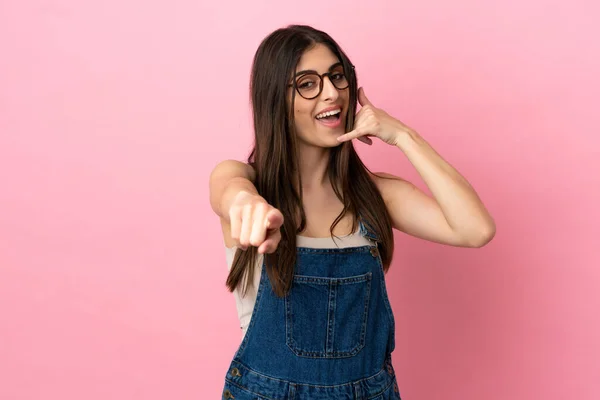 Mulher Caucasiana Jovem Isolado Fundo Rosa Fazendo Gesto Telefone Apontando — Fotografia de Stock