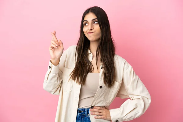 Jonge Kaukasische Vrouw Geïsoleerd Roze Achtergrond Met Vingers Kruisen Wensen — Stockfoto