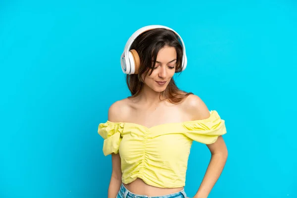 Joven Mujer Caucásica Aislada Sobre Fondo Azul Escuchando Música —  Fotos de Stock