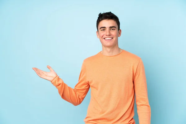 Teenager Caucasian Handsome Man Isolated Purple Background Holding Copyspace Imaginary — Stock Photo, Image