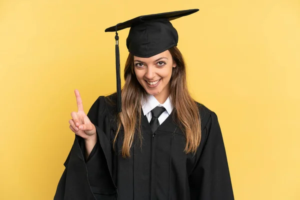 Νεαρός Απόφοιτος Πανεπιστημίου Απομονώνονται Κίτρινο Φόντο Δείχνει Και Άρει Ένα — Φωτογραφία Αρχείου