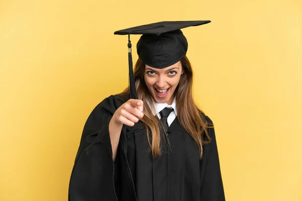 Joven Graduado Universitario Aislado Sobre Fondo Amarillo Sorprendido Apuntando Frente — Foto de Stock