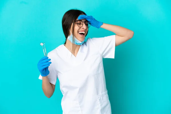 Junge Kaukasische Zahnärztin Frau Mit Werkzeugen Isoliert Auf Blauem Hintergrund — Stockfoto