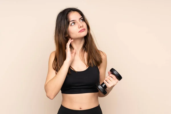 Jovem Mulher Esporte Fazendo Levantamento Peso Isolado Fundo Bege Pensando — Fotografia de Stock