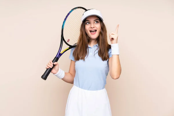 Νεαρή Λευκή Γυναίκα Απομονωμένη Μπεζ Φόντο Παίζοντας Τένις Και Δείχνοντας — Φωτογραφία Αρχείου