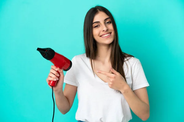 Joven Mujer Caucásica Sosteniendo Secador Pelo Aislado Sobre Fondo Azul — Foto de Stock