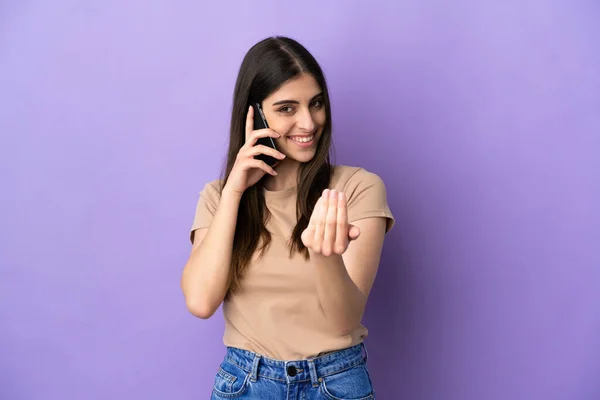 Молодая Кавказская Женщина Используя Мобильный Телефон Изолированный Фиолетовом Фоне Приглашает — стоковое фото