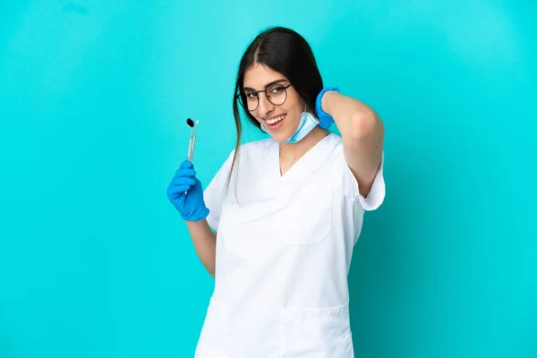 Junge Kaukasische Zahnärztin Hält Werkzeuge Isoliert Auf Blauem Hintergrund Und — Stockfoto