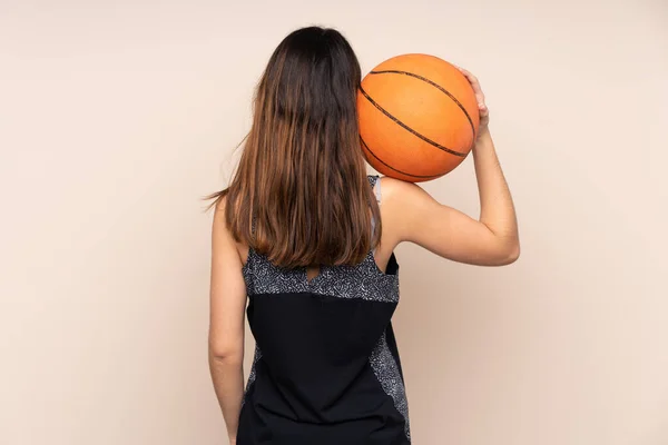 在米色背景下被隔离的年轻的高加索女人 在篮球场上背靠背打篮球 — 图库照片