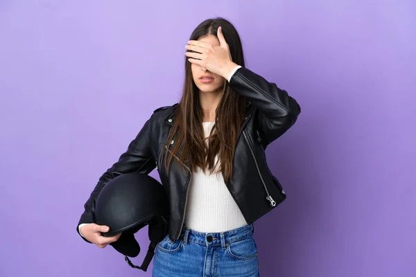 紫色の背景に手で目をカバーに隔離されたオートバイのヘルメットを持つ若い白人女性 何か見たくない — ストック写真