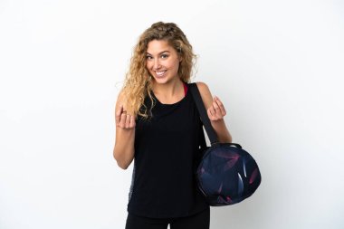 Spor çantalı genç bir kadın beyaz arka planda izole edilmiş para hareketi yapıyor.