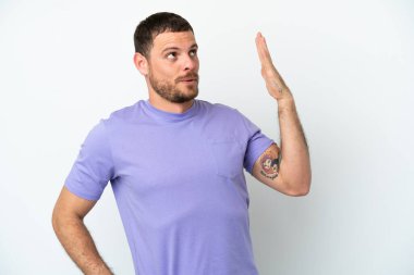 Genç Brezilyalı adam beyaz arka planda izole edilmiş, yorgun ve hasta bir ifadeyle.