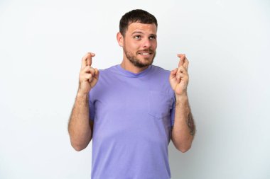 Genç Brezilyalı adam beyaz arka planda izole edilmiş, şans diliyor ve en iyisini diliyor.