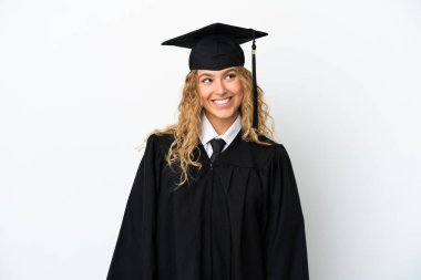 Genç üniversite mezunu beyaz arka planda izole edilmiş bir şekilde bir fikir ararken...