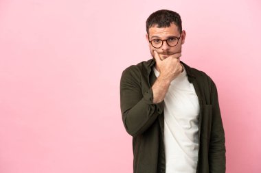 Pembe arka planda izole edilmiş genç Brezilyalı adamın şüpheleri var.