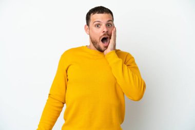 Genç Brezilyalı adam beyaz arka planda izole edilmiş, şaşırmış ve şok olmuş bir yüz ifadesi var.