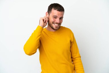 Genç Brezilyalı adam beyaz arka planda izole edilmiş gülüyor.