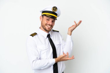 Brezilya uçağı pilotu, beyaz arka planda izole edilmiş ve davet edilmek üzere ellerini yana uzatıyor.