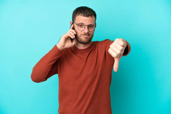 Mavi Arka Planda Izole Edilmiş Cep Telefonu Kullanan Genç Brezilyalı — Stok fotoğraf