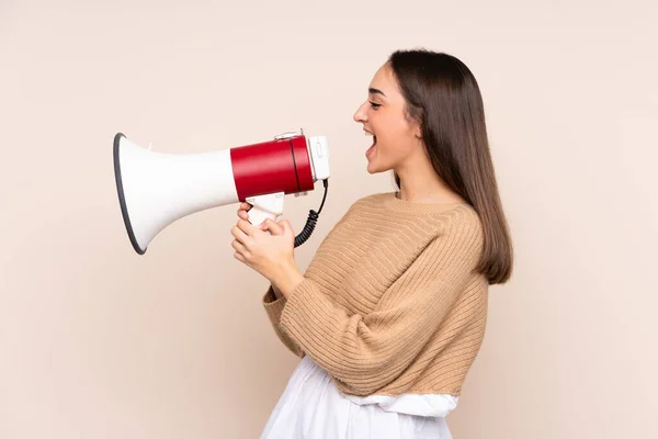 Jonge Kaukasische Vrouw Geïsoleerd Beige Achtergrond Schreeuwen Door Een Megafoon — Stockfoto