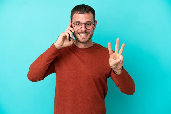 Mladý Brazilský Muž Pomocí Mobilního Telefonu Izolované Modrém Pozadí Šťastný — Stock fotografie