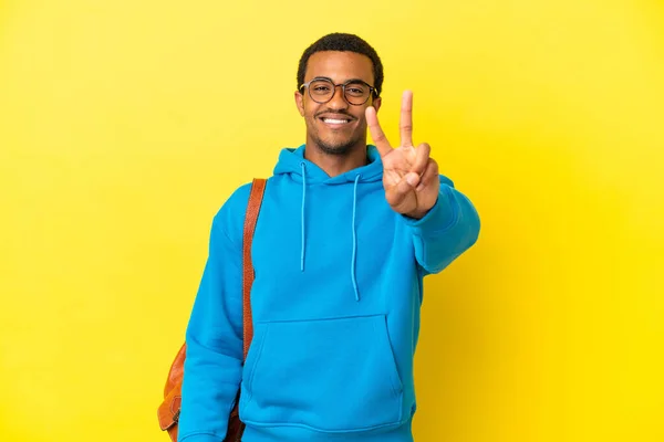 Африканський Американський Студент Над Ізольованим Жовтим Фоном Посміхається Показує Знак — стокове фото