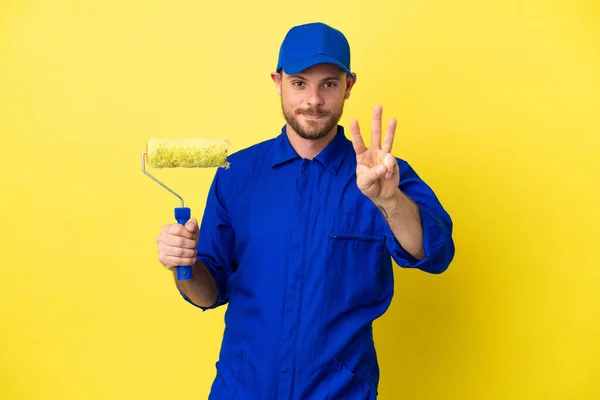 画家ブラジル人男性は黄色の背景に幸せと指で3を数える — ストック写真