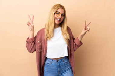 Genç Uruguaylı sarışın kadın iki eliyle zafer işareti gösteriyor.