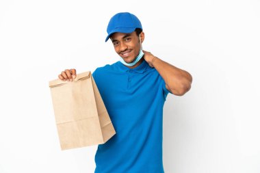 Beyaz arka planda izole edilmiş bir paket yiyecek alan Afro-Amerikalı adam gülüyor.