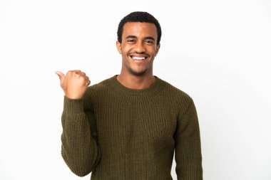 İzole edilmiş beyaz arka planda Afro-Amerikalı yakışıklı bir adam bir ürün sunmak için kenarı işaret ediyor
