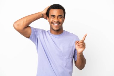 İzole edilmiş beyaz arka plandaki Afro-Amerikalı yakışıklı adam şaşırdı ve parmağını yana çevirdi.