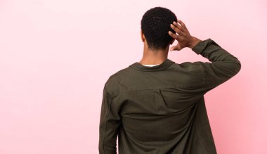 Telif uzayındaki Afro-Amerikalı adam arka planda pembe arka planda ve düşünüyor