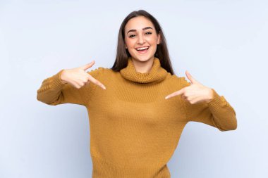 Mavi arka planda soyutlanmış, gururlu ve kendini beğenmiş beyaz bir kadın.