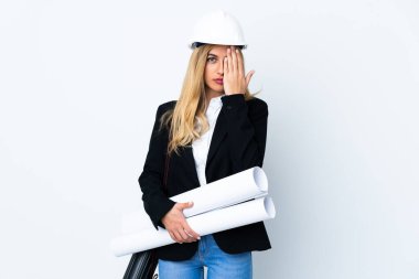 Miğferli genç bir mimar kadın, bir gözü kaplayan ve izole edilmiş beyaz bir arka planın planlarını elinde tutuyor.