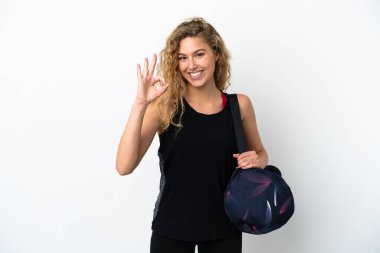 Spor çantalı genç bayan beyaz arka planda izole edilmiş. Parmaklarıyla işaret veriyor.