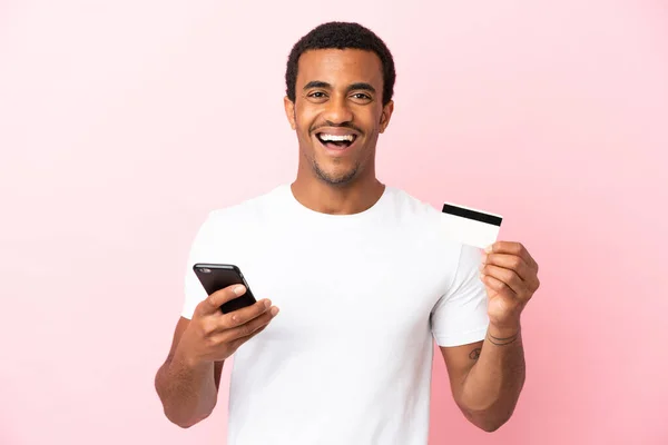 Afroamerykanin Przystojny Mężczyzna Odizolowanym Różowym Tle Zakup Telefonu Komórkowego Trzymając — Zdjęcie stockowe