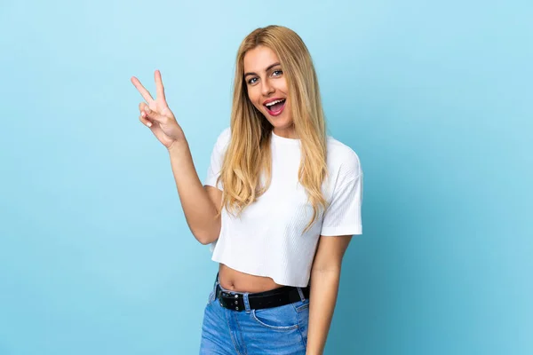 Jovem Mulher Loira Uruguaia Sobre Fundo Azul Isolado Sorrindo Mostrando — Fotografia de Stock