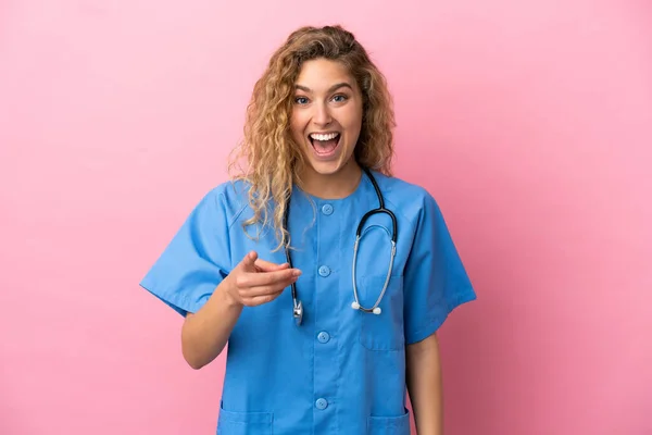 若いです外科医女性隔離上のピンクの背景驚きと指摘フロント — ストック写真