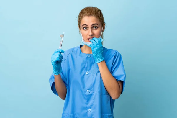 Mladá Žena Zubař Drží Nástroje Přes Izolované Modré Pozadí Nervózní — Stock fotografie