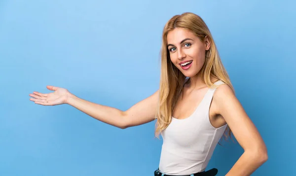 Ung Uruguayansk Blond Kvinna Över Isolerad Bakgrund Sträcker Händerna Sidan — Stockfoto