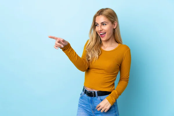 Jovem Loira Uruguaia Sobre Fundo Azul Isolado Apontando Dedo Para — Fotografia de Stock