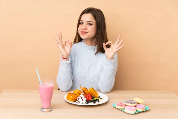 Chica Adolescente Comiendo Gofres Aislados Sobre Fondo Beige Pose Zen — Foto de Stock